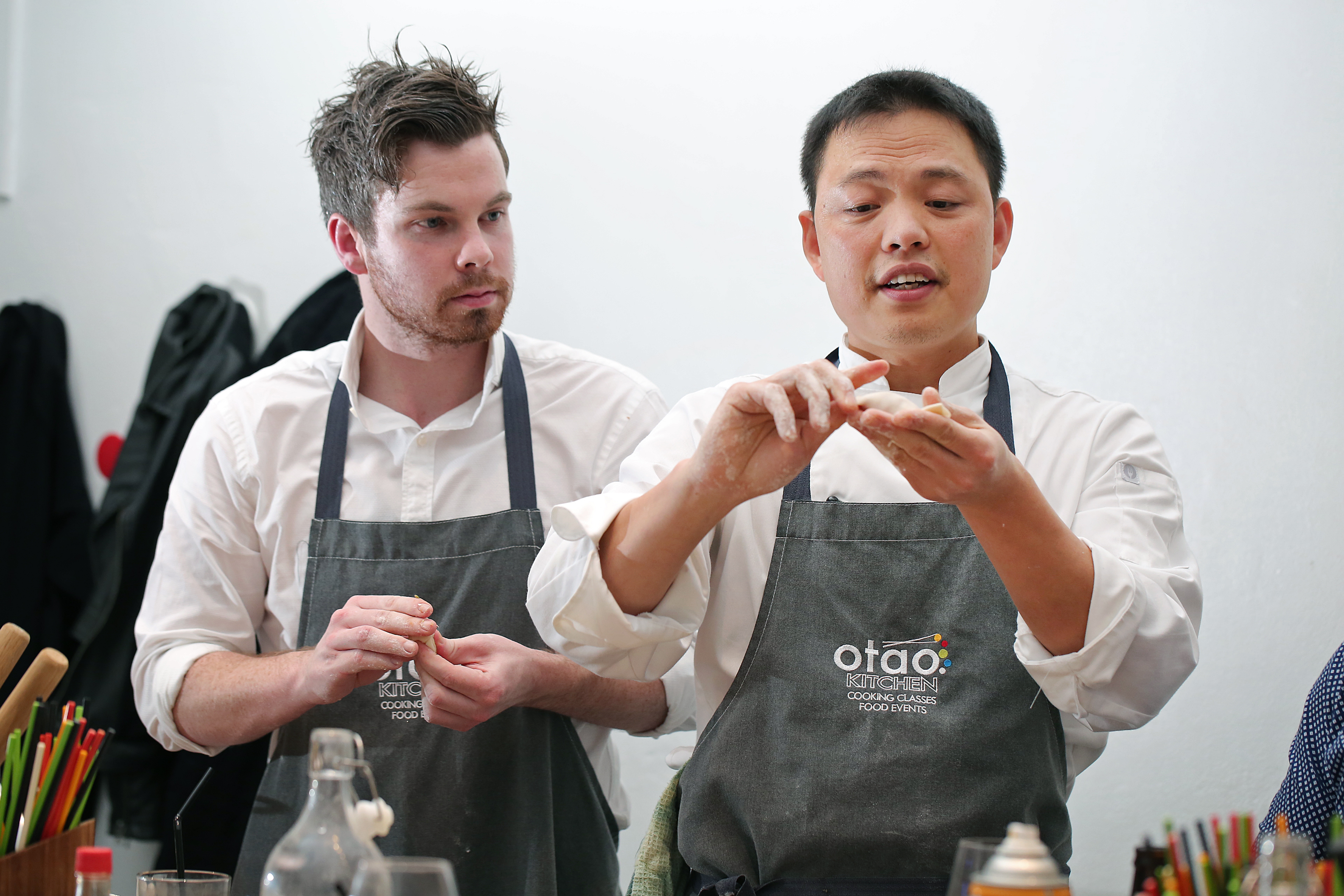 two men demonstarting a cooking technique 