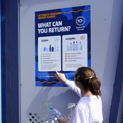 Girl looks at Container Deposit Scheme vending machine guide