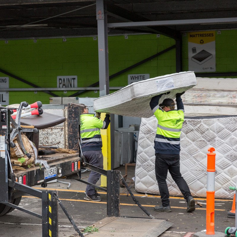 Yarra City Council workers move mattresses at the Council depot. 