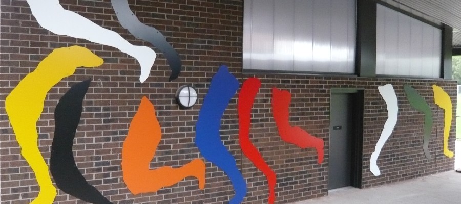 Artwork on pavilion wall, shows colourful legs in leaping and kicking motion