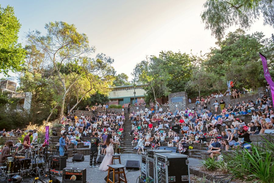 A band plays in front of a crowd sitting on the blue stone steps at Fairfield Amphitheatre