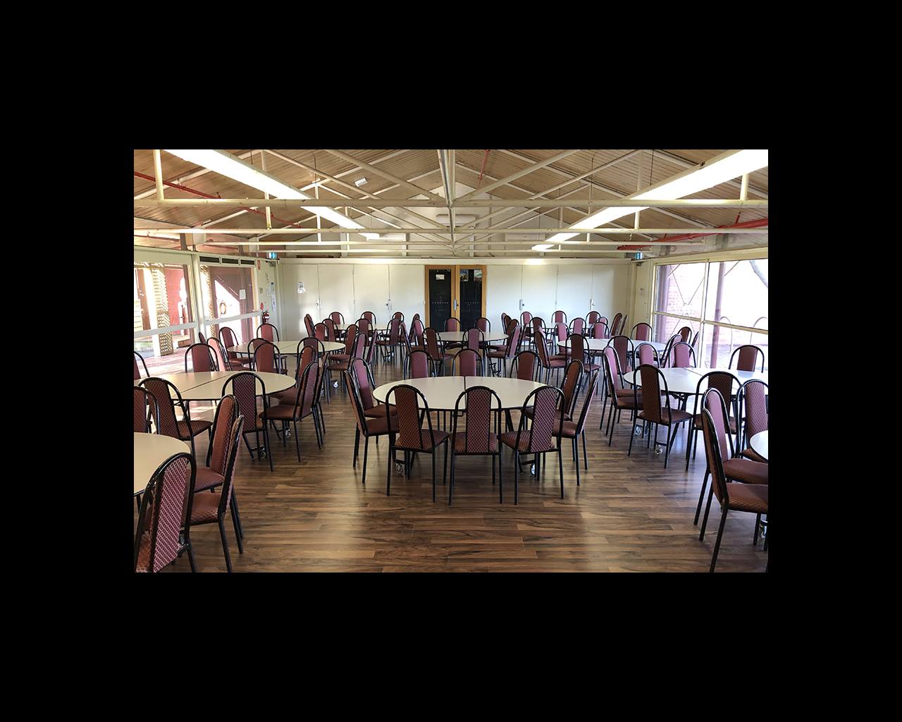 A community hall with round tables and chairs setup for a function