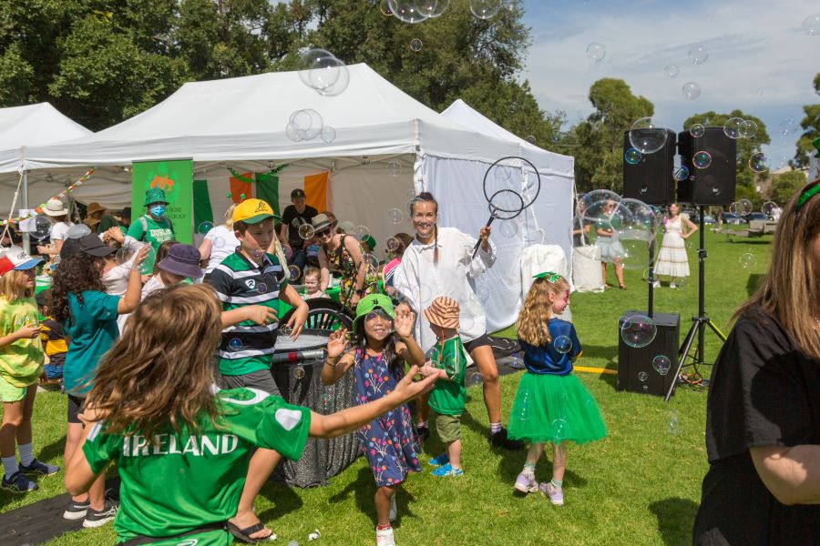 Children playing at an event, wearing green