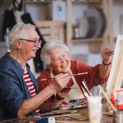 Two older people painting together