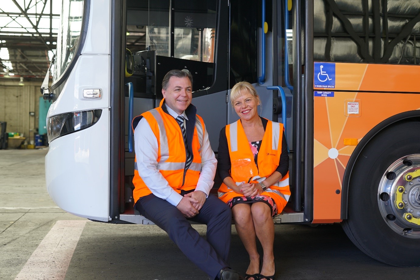 Mayor and Transdev manager sitting on steps of new electric bus