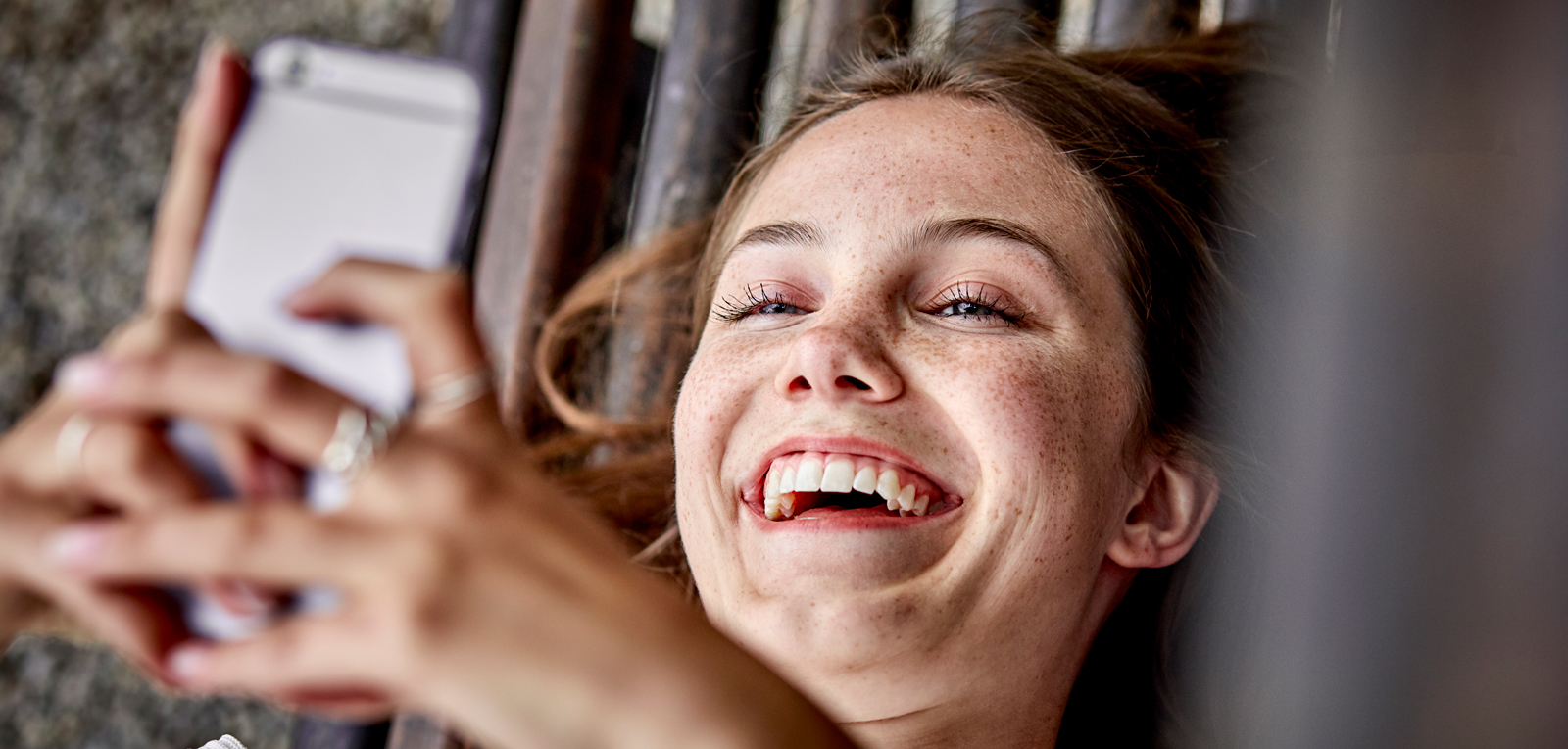Woman laughing while looking at her mobile phone