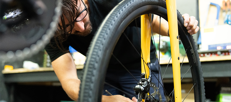 man in glasses fixing bike wheel 