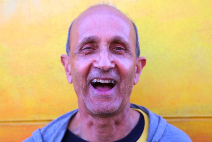 Man smiling with a yellow background.
