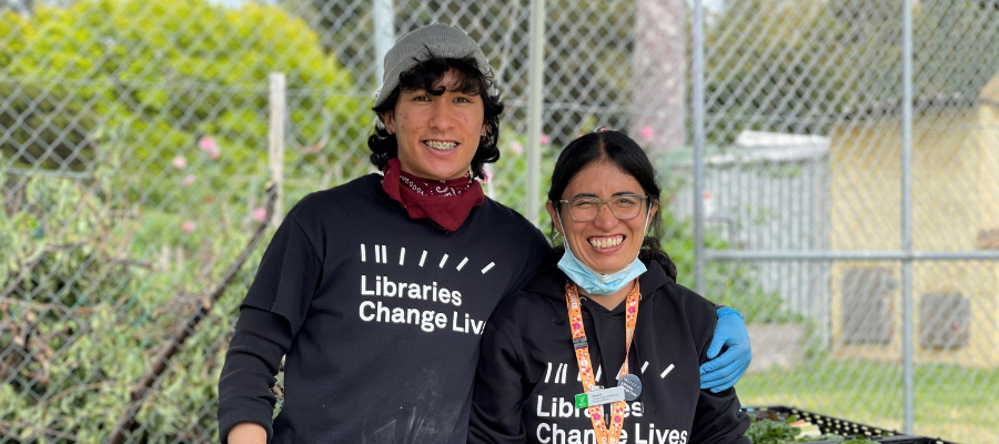 Two library staff wearing Libraries Change Lives t-shits smiling