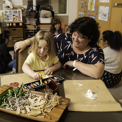Female teacher teaching child at table