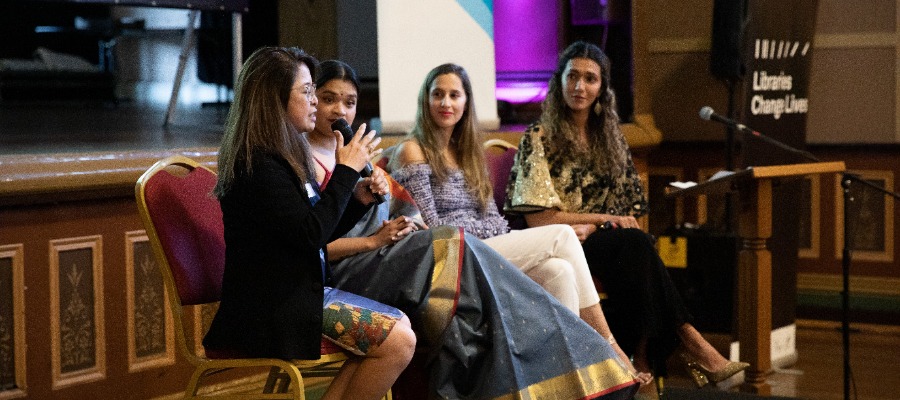 Four international womens day panellists speaking at an event