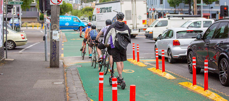 a group of people cycling and scooting on protected bike lanes