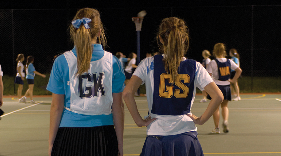 Two girls on a netball court