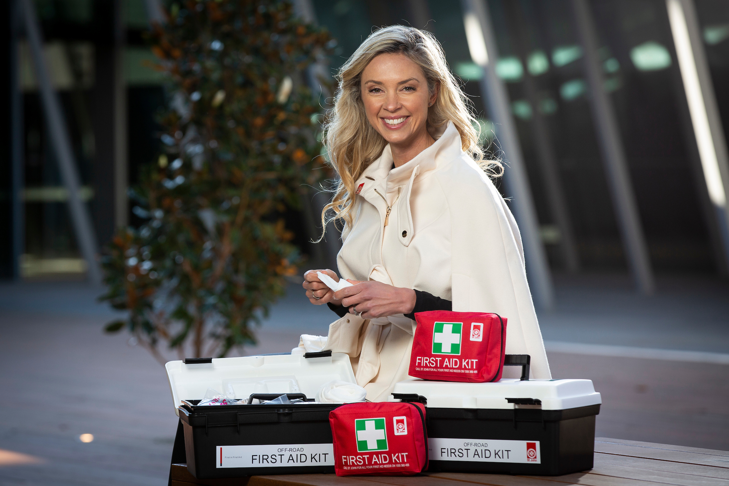 St Johns Ambulance blonde woman sitting next to first aid kits