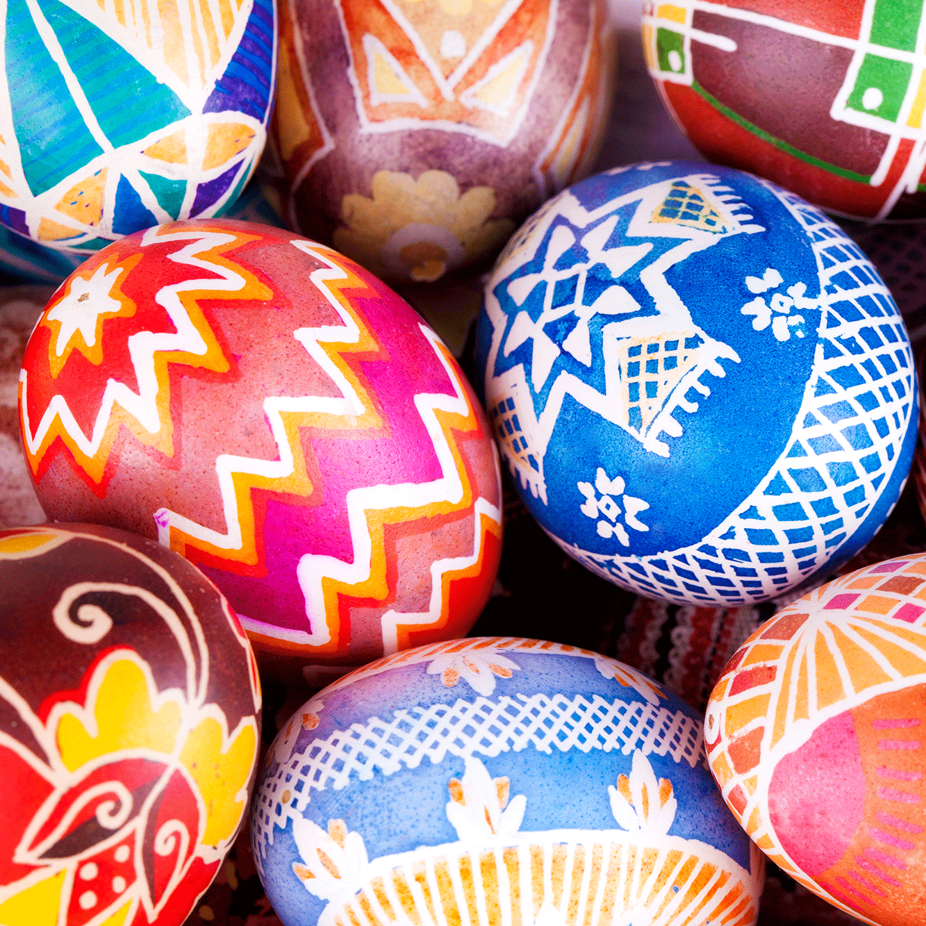 Eggs painted with bright patterns in blue, red, pink orange and yellow