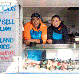 A man and a woman smiling in a mobile store with seafood for sale