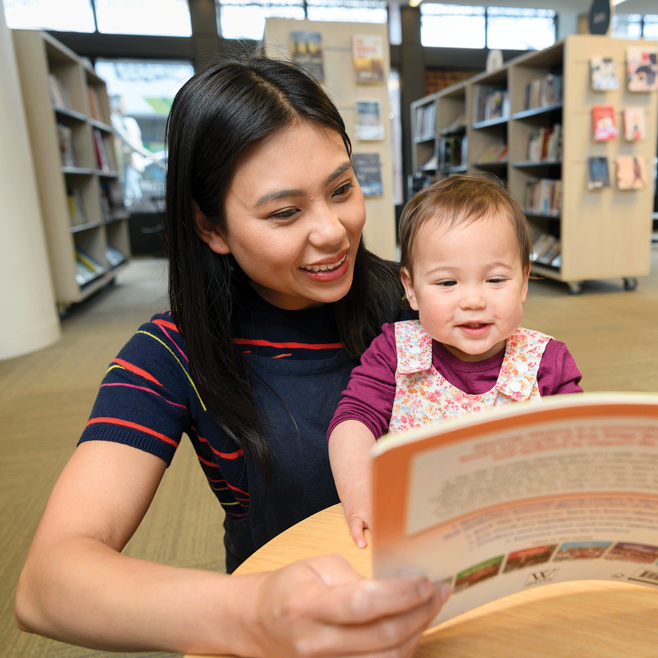 A women reading to her daughter in a library