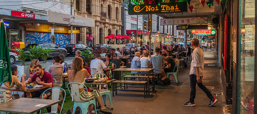 streetscape in Yarra with multiple people using outdoor dining spaces including parklets