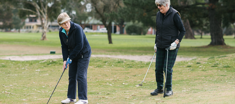 Two elderly women playing golf at Burnley Gold Course