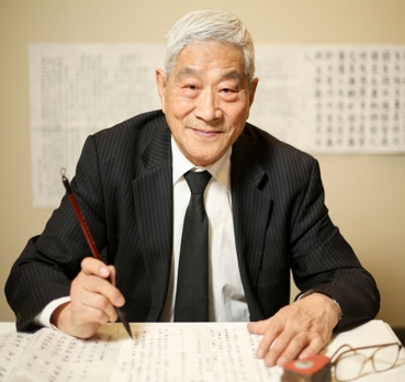 Man demonstrating chinese calligraphy as part of chinese reading month