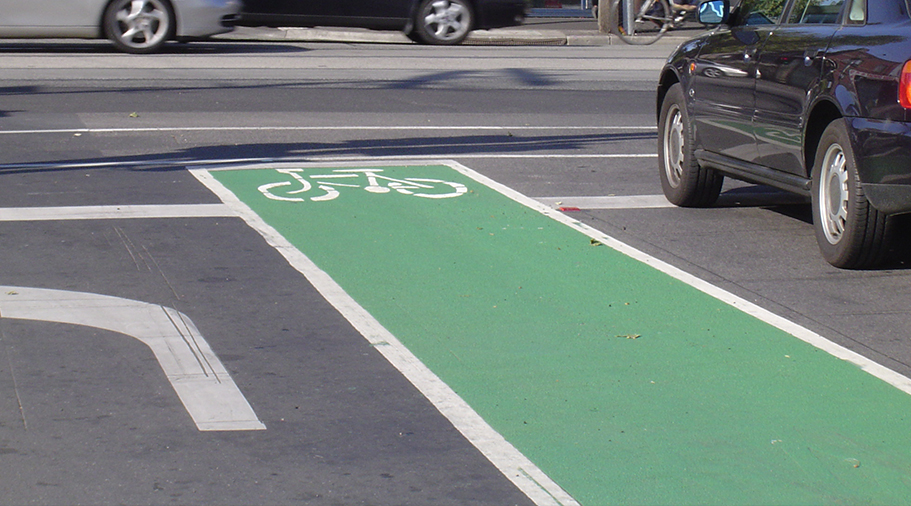A green bike lane in Yarra betwen cars. 