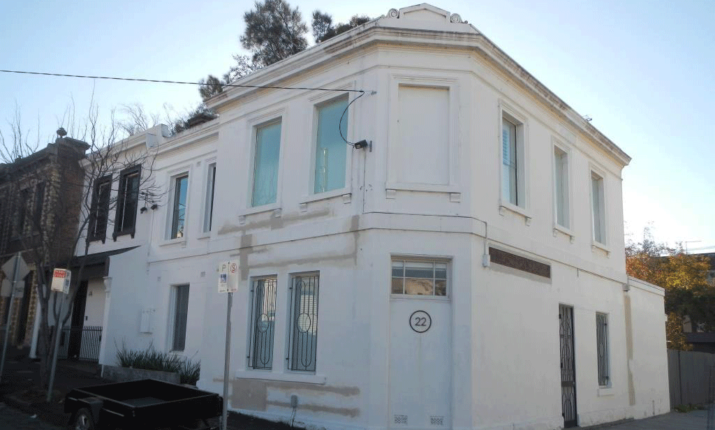 A cream coloured heritage building below a blue sky