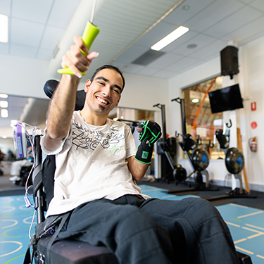 A young man smiling and exercising in the Empower+ Program at Richmond Recreation Centre