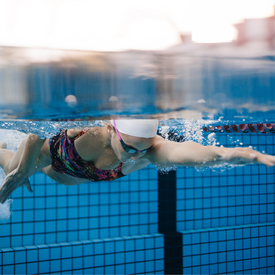 A woman swimming freestyle with an outreached arm